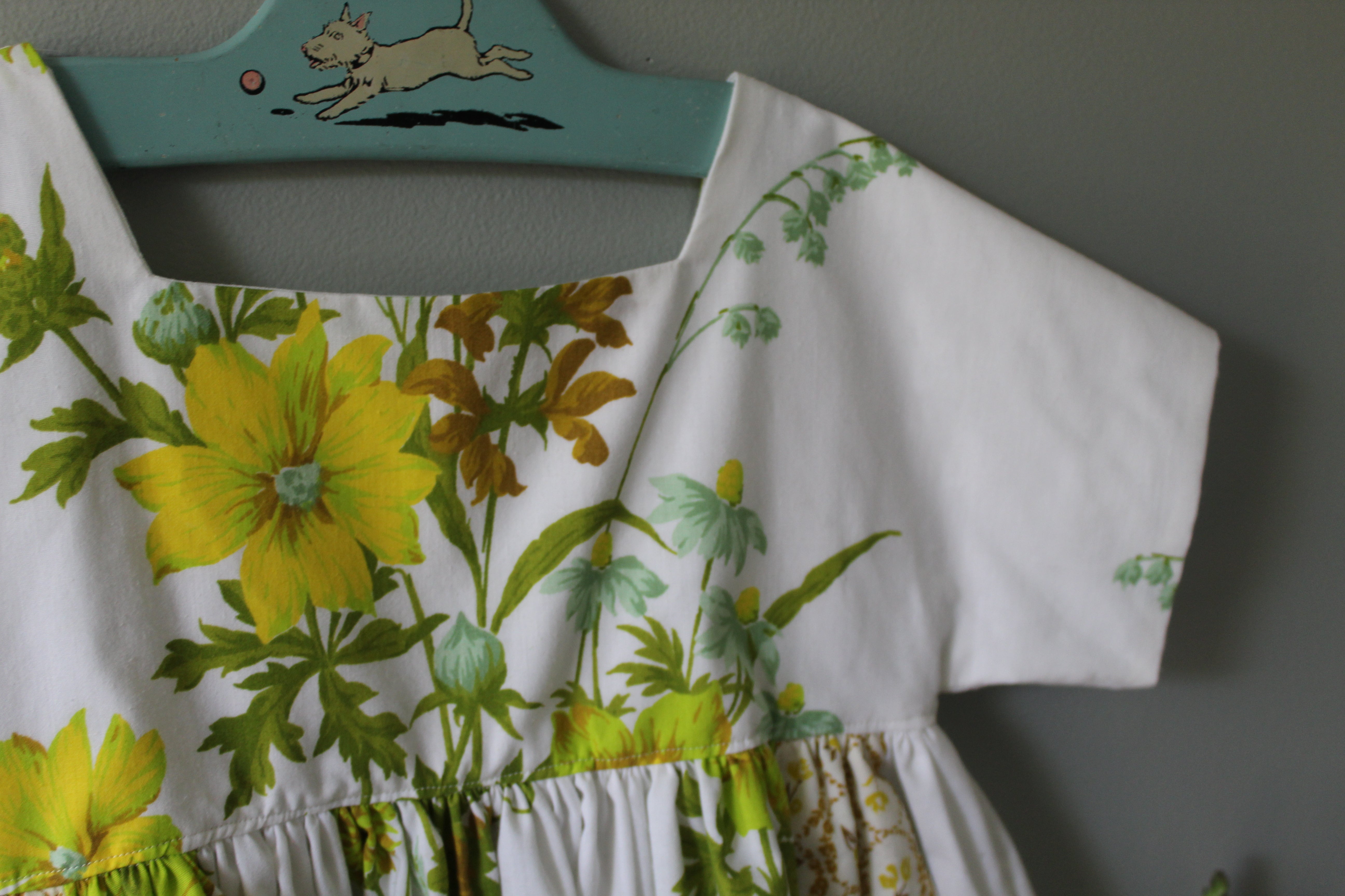 Floral dress on a hanger against a gray wall