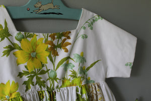 Floral dress on a hanger against a gray wall