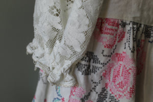 Close-up of a garment with lace detailing and floral patterns.