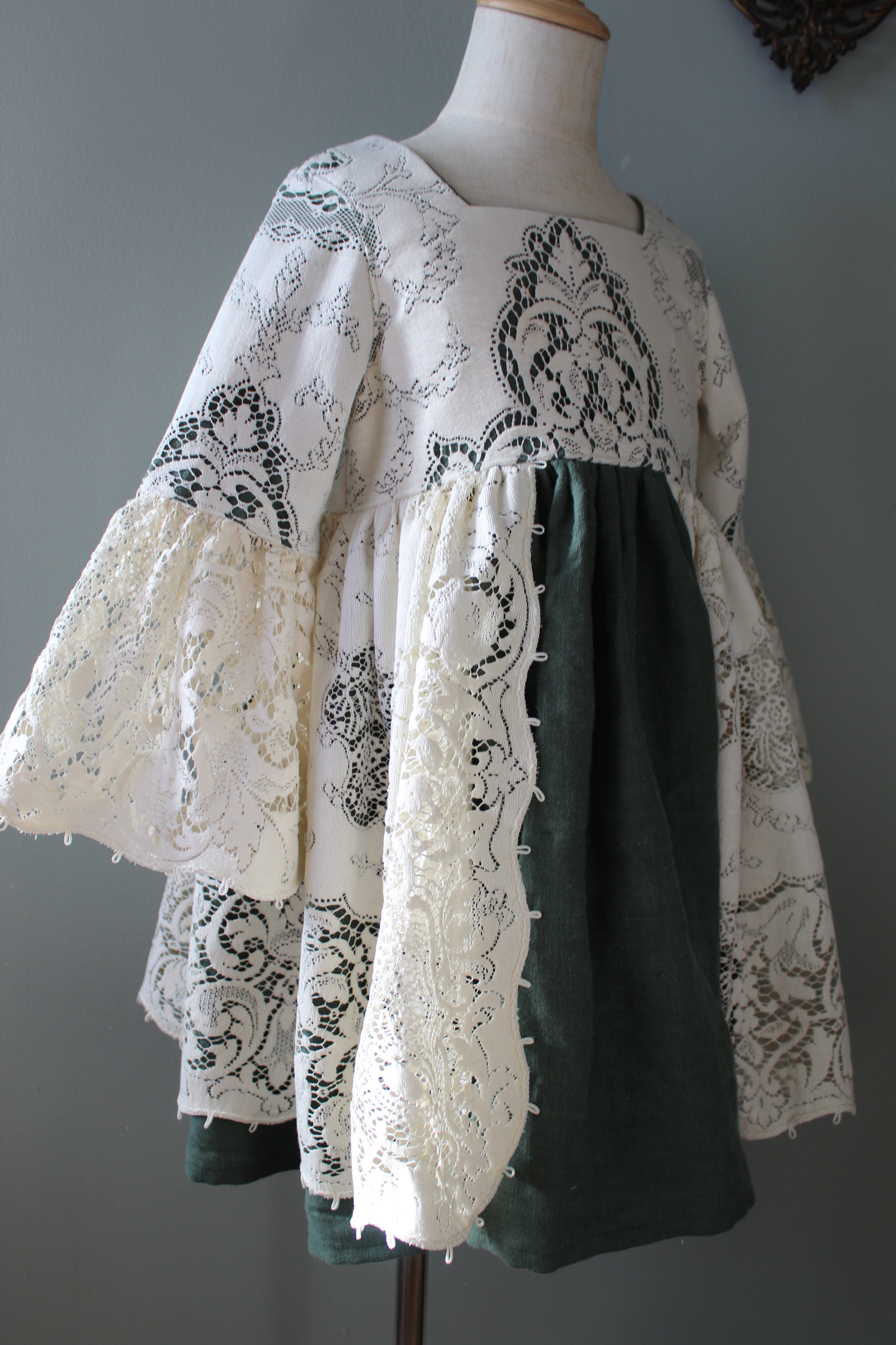 Stack of green and white patterned fabric on a mannequin against a gray background