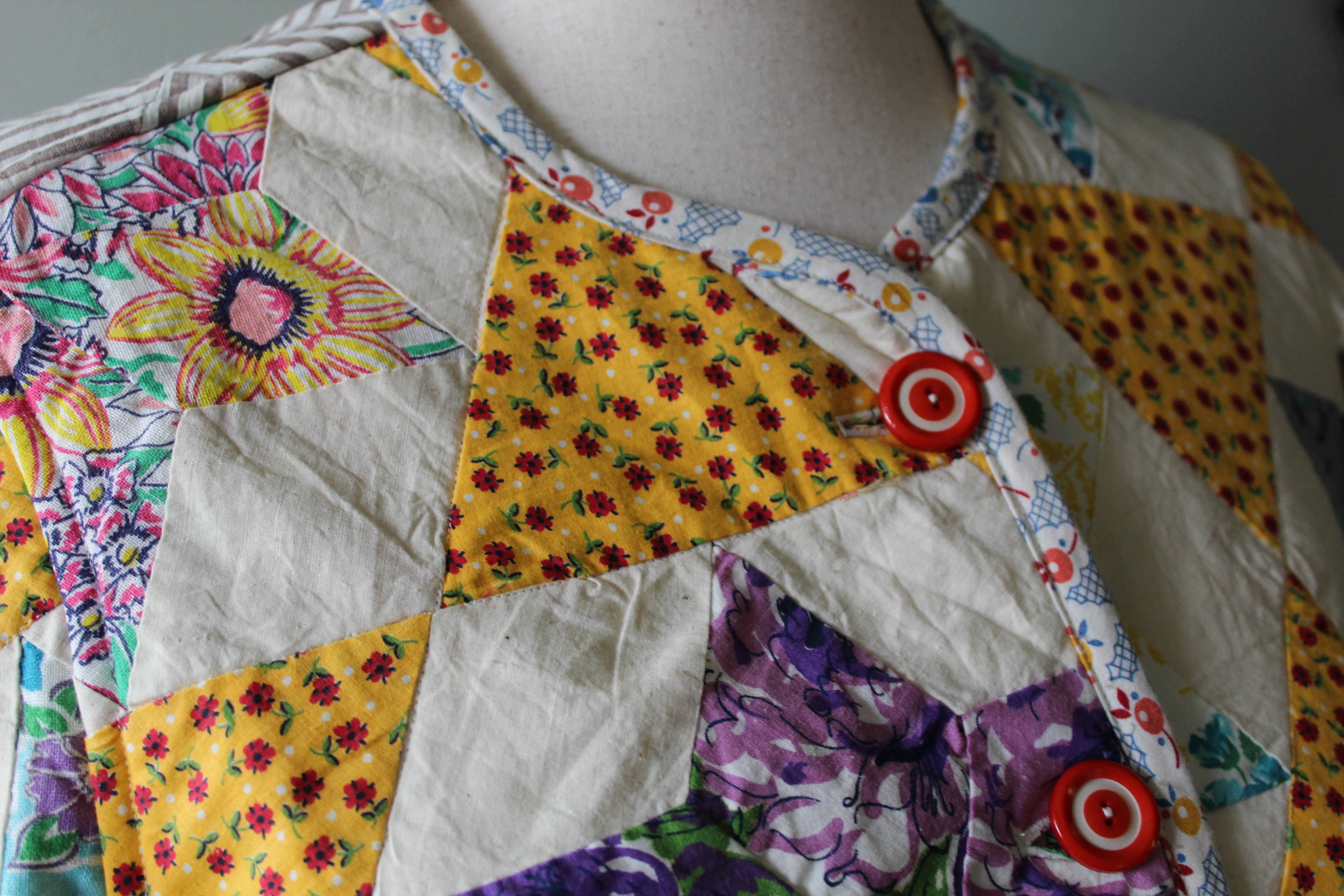 Colorful patchwork coat on a mannequin with floral patterns and buttons.
