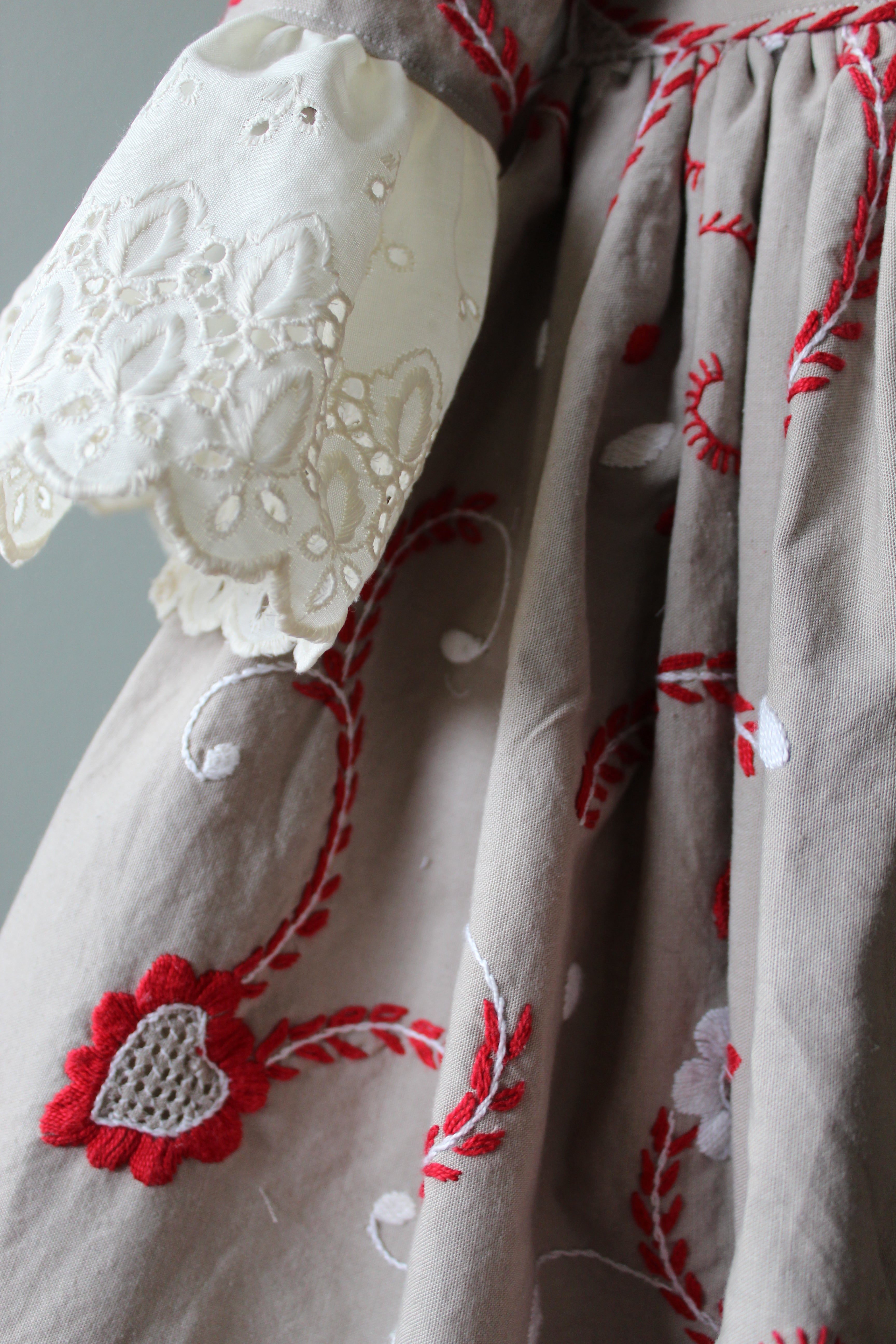 Textile with red floral embroidery on a white background