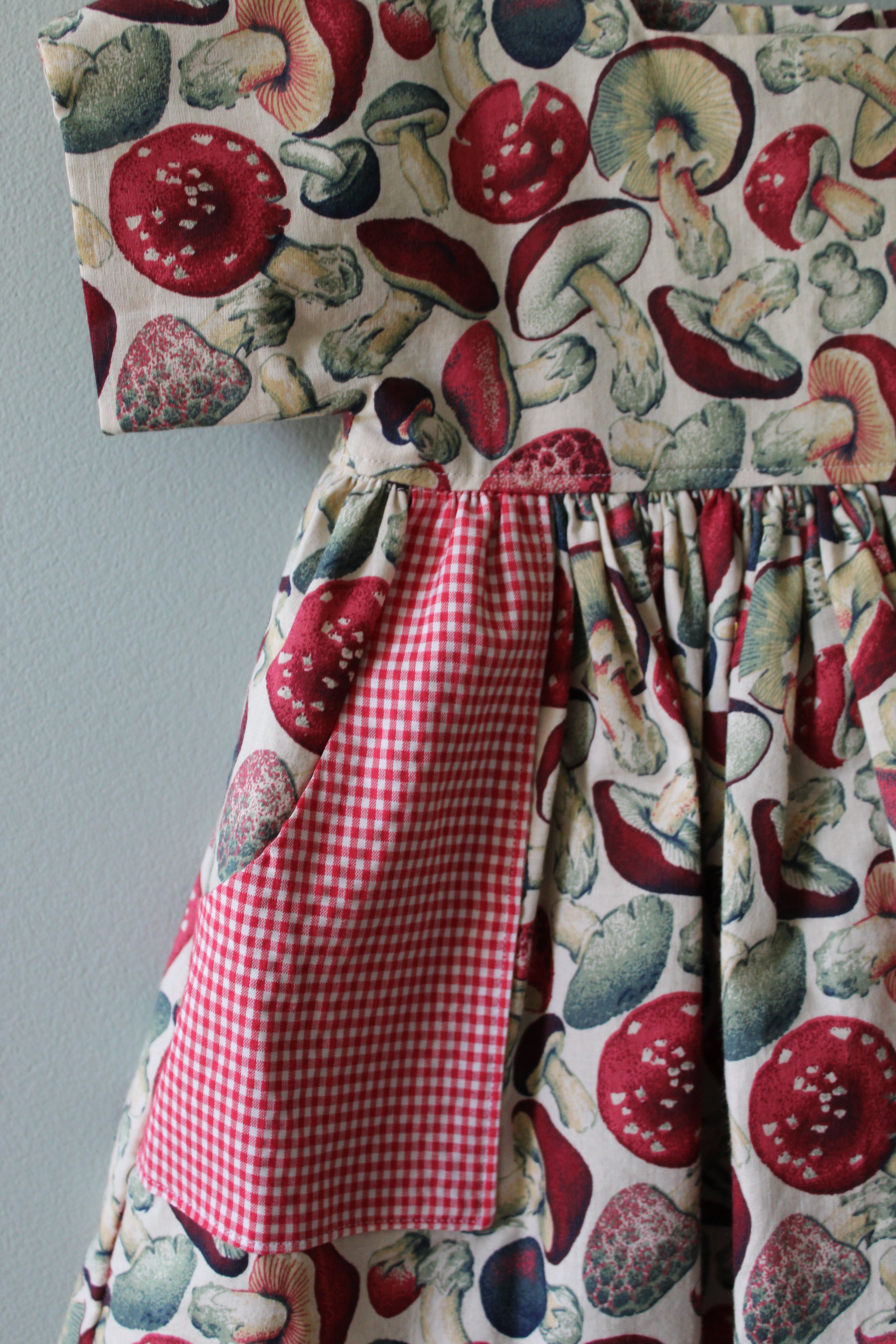 Fabric with mushroom pattern and red checkered fabric on a gray background