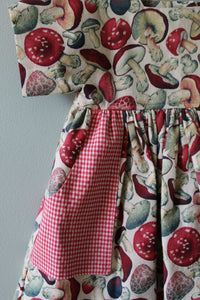 Fabric with mushroom pattern and red checkered fabric on a gray background