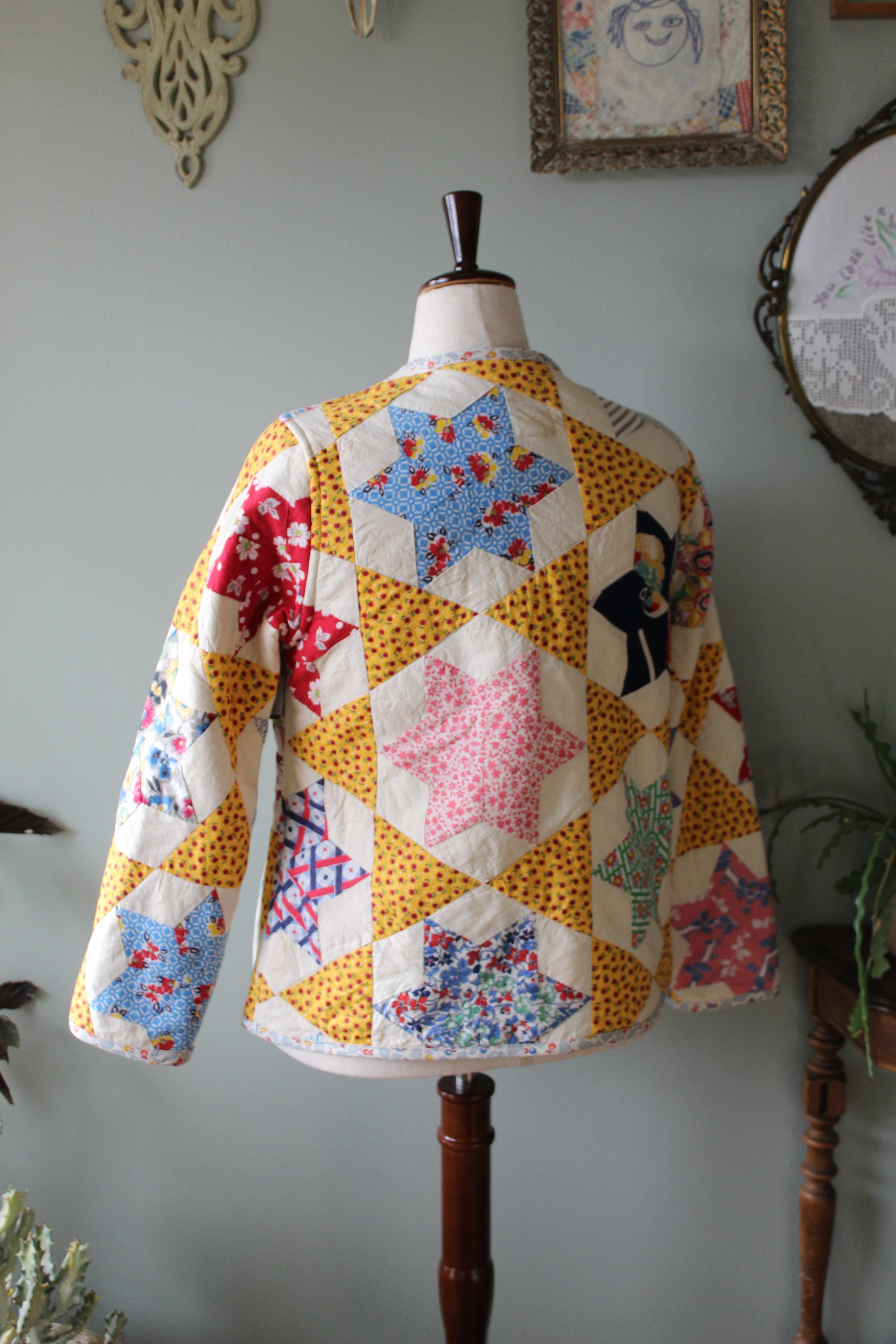 Quilted coat on a mannequin with star patterns against a neutral background