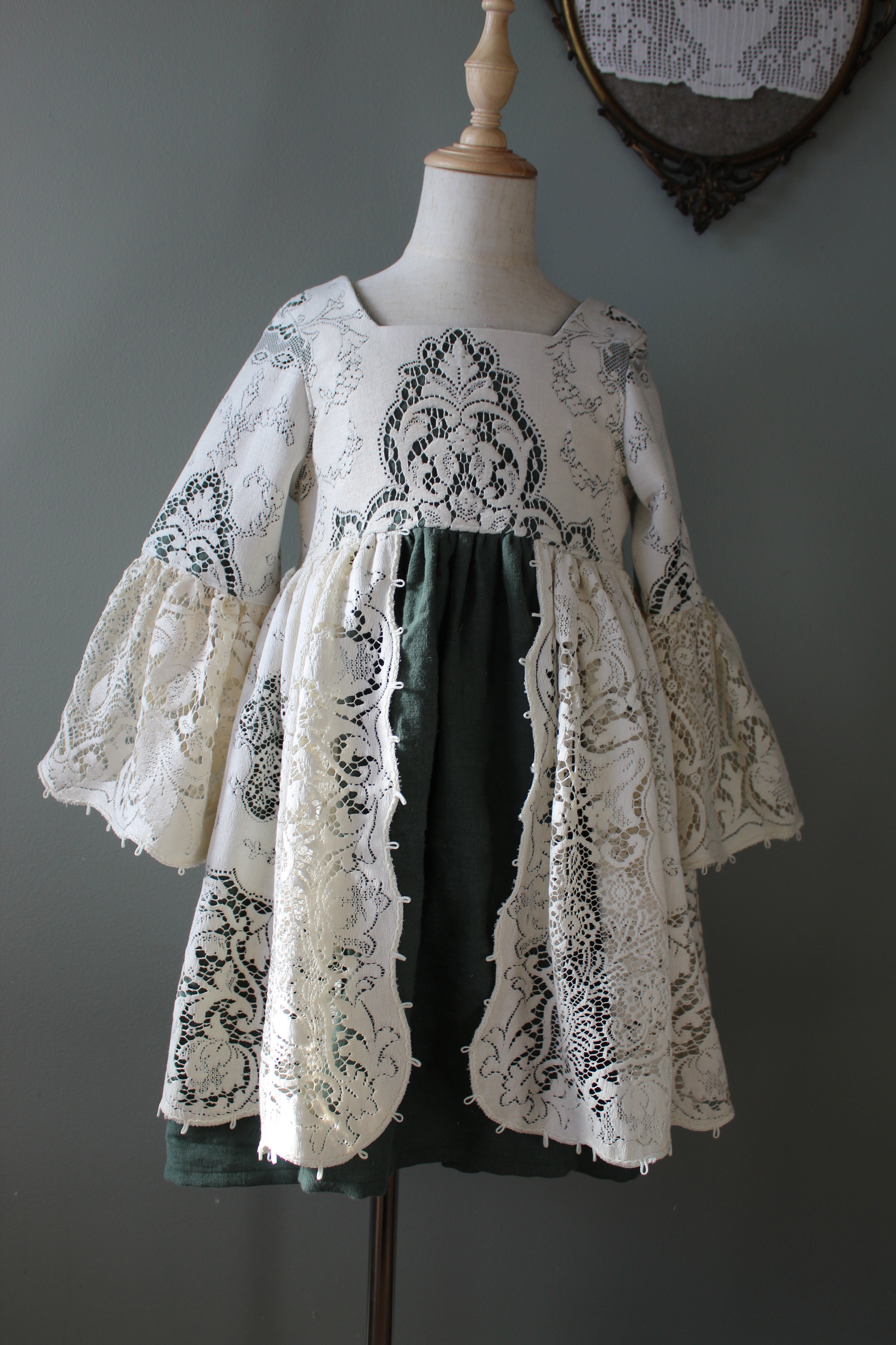 Lace dress on a mannequin against a gray background