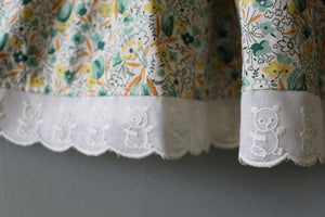 Close-up of floral fabric with white lace trim on a plain background