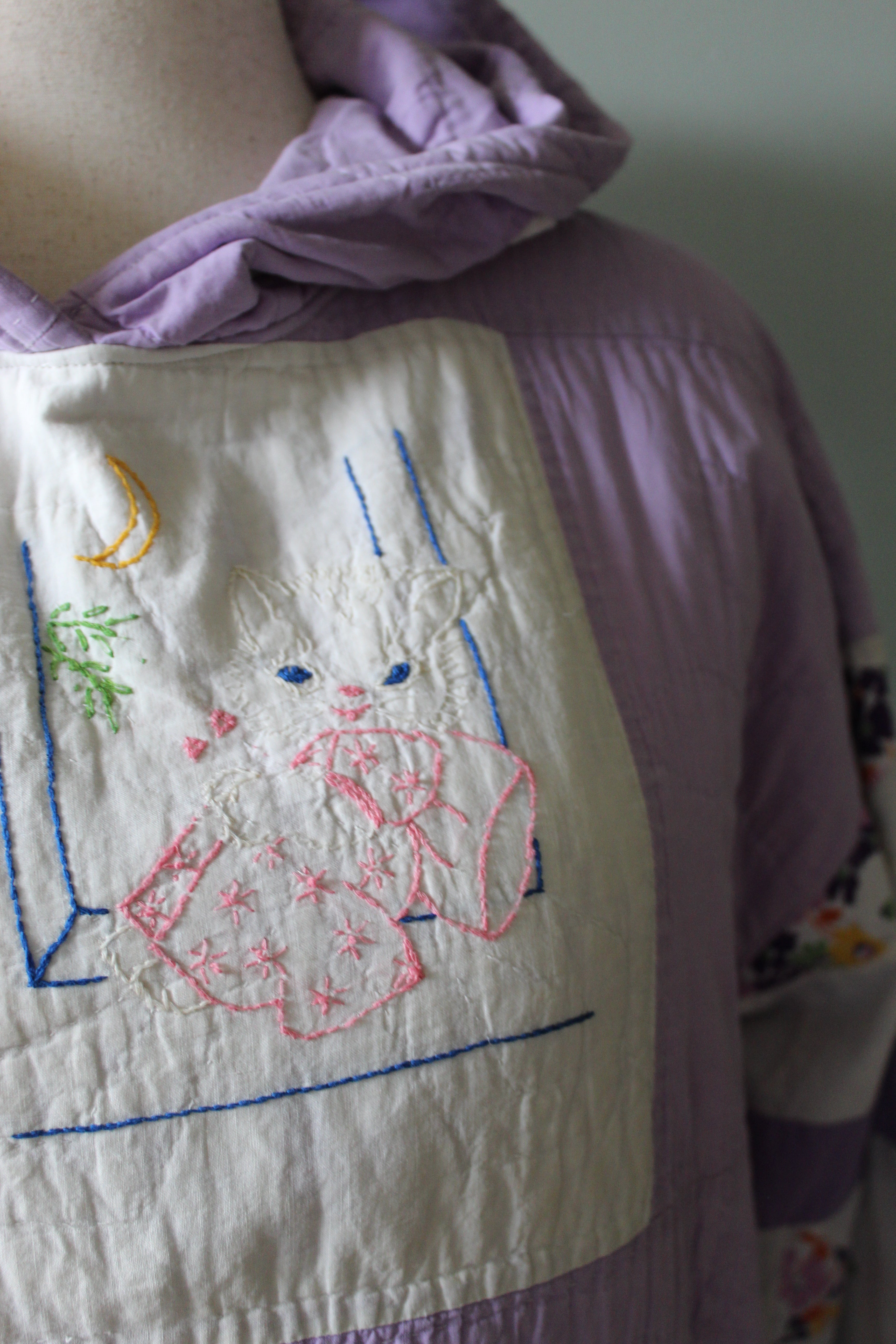 Embroidered kitten fabric with a design on a purple garment