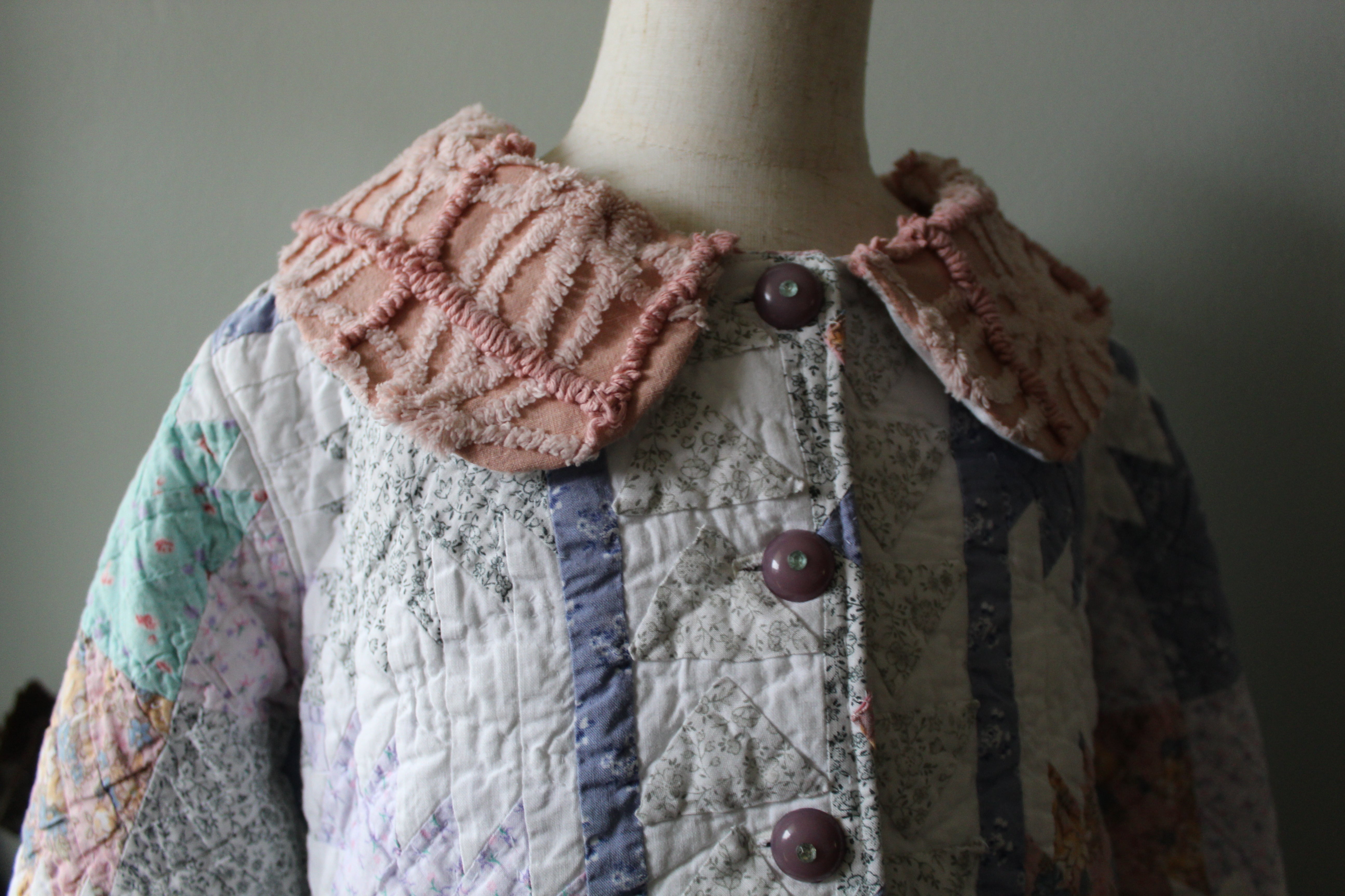 Quilted jacket with floral pattern on a mannequin against a plain background