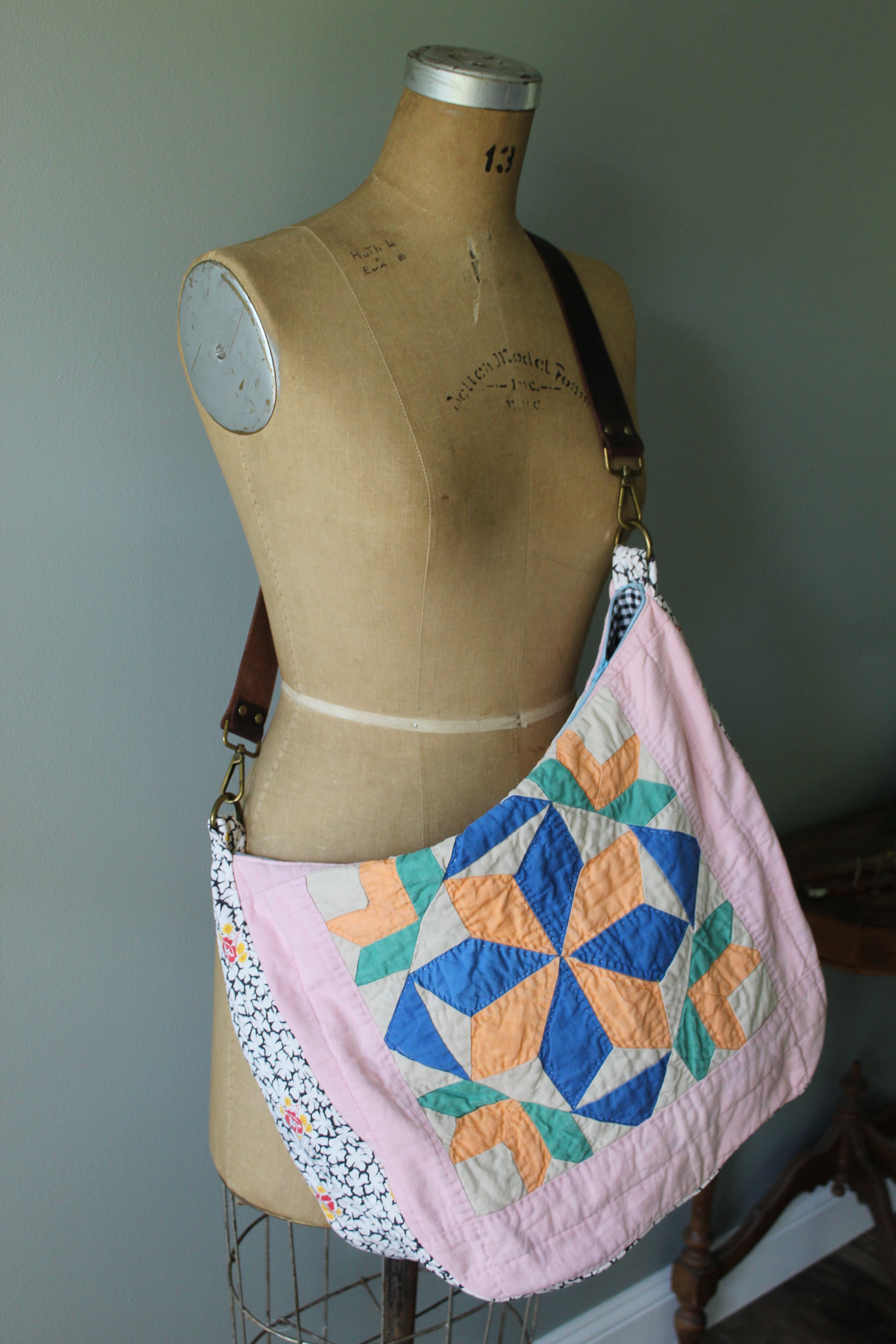 Mannequin wearing a colorful quilt with a geometric pattern against a plain background