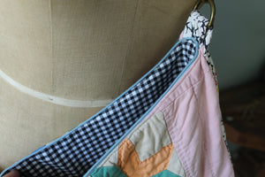 Patchwork quilt with colorful patterns hanging on a mannequin