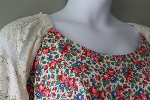Mannequin wearing a floral dress with a lace overlay against a neutral background