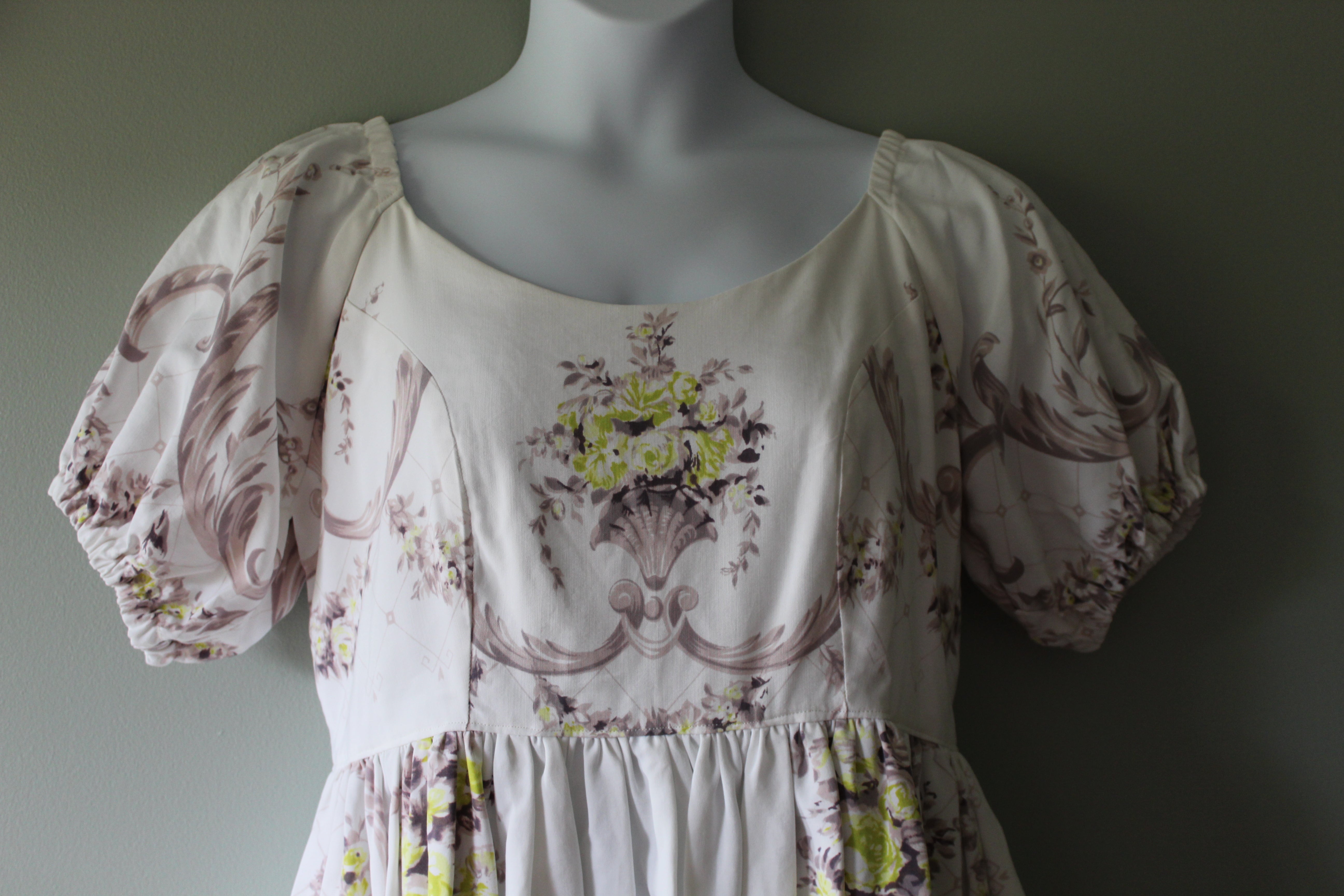 Mannequin wearing a floral dress with puff sleeves against a plain background